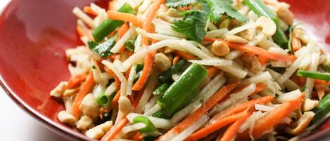 A bowl of salad with various vegetables and peanuts.