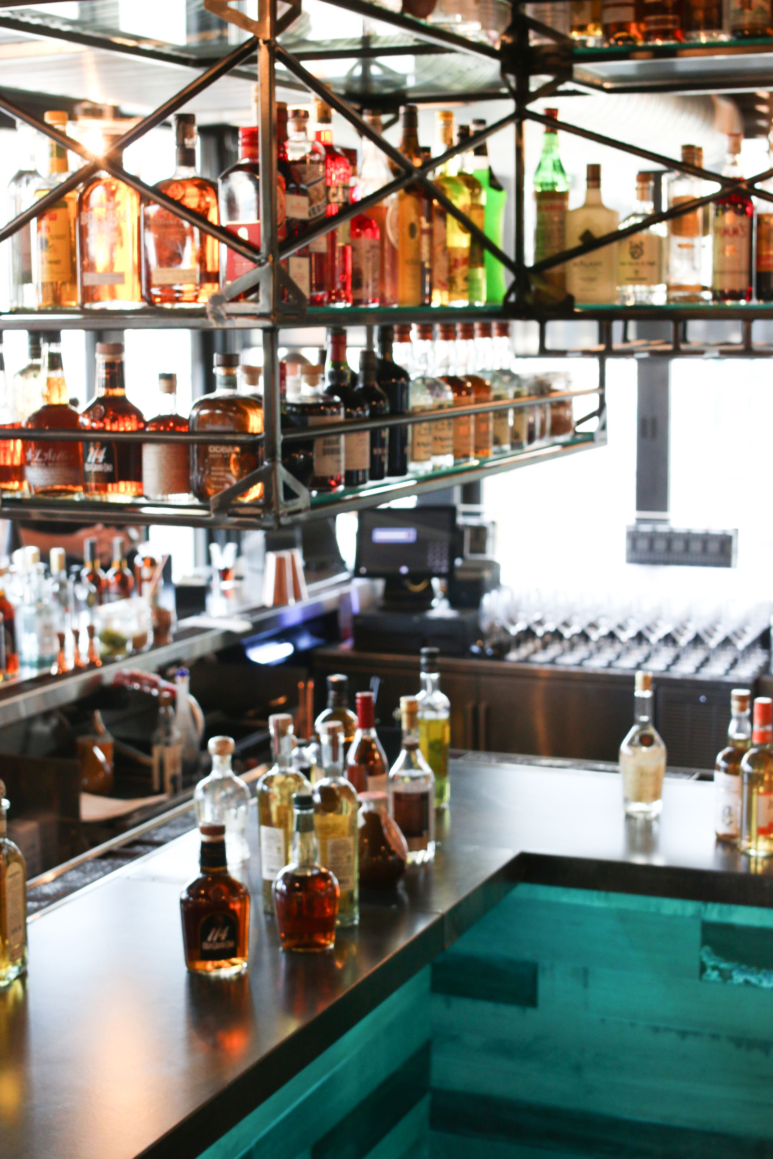 A bar with shelves of liquor bottles and glasses.