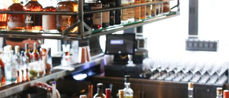 A bar with shelves of liquor bottles and glasses.