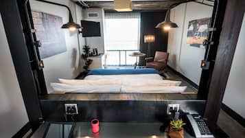 Una habitación de hotel moderna con cama, escritorio y dos lámparas.