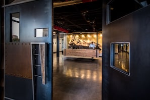 A spacious lobby with a large mural, a reception desk, and a modern industrial design.