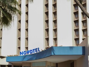 A hotel with a modern facade, balconies with flower boxes, and the name 'NOVOTEL' prominently displayed. - Novotel Dakar (Dakar)