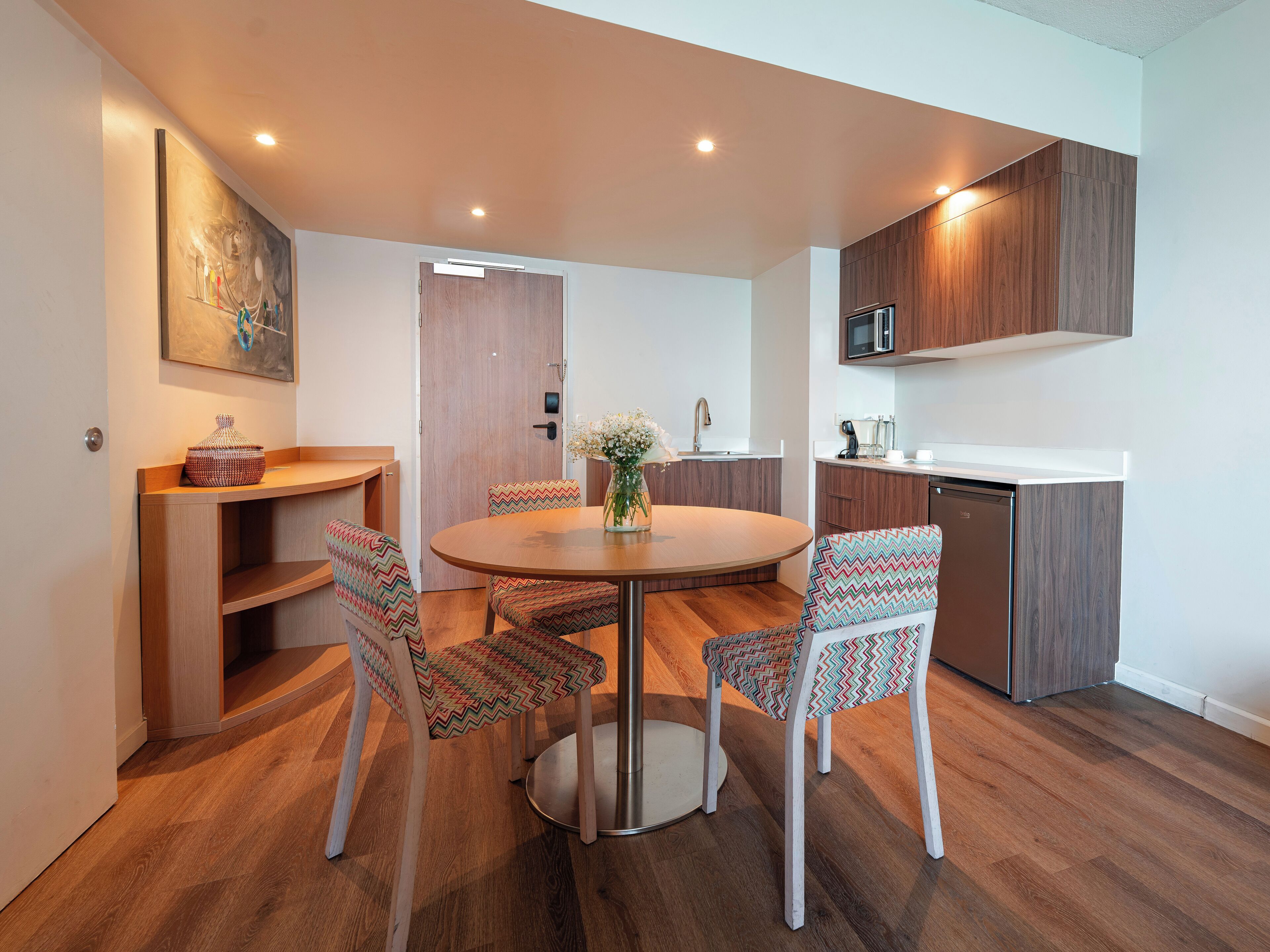 Una cocina moderna con armarios de madera, microondas integrado y lavavajillas.