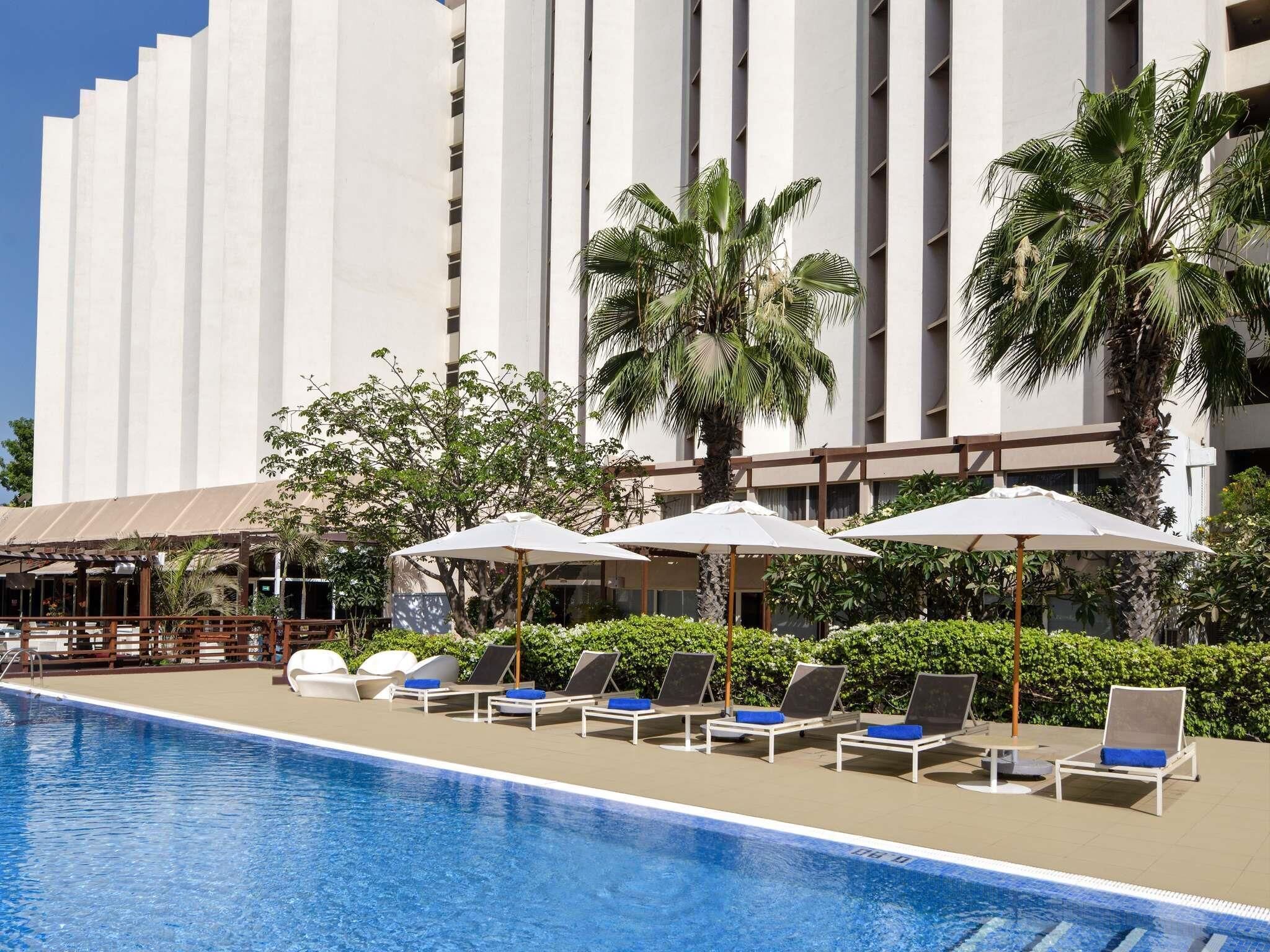 Una piscina al aire libre, sillones reclinables de piscina