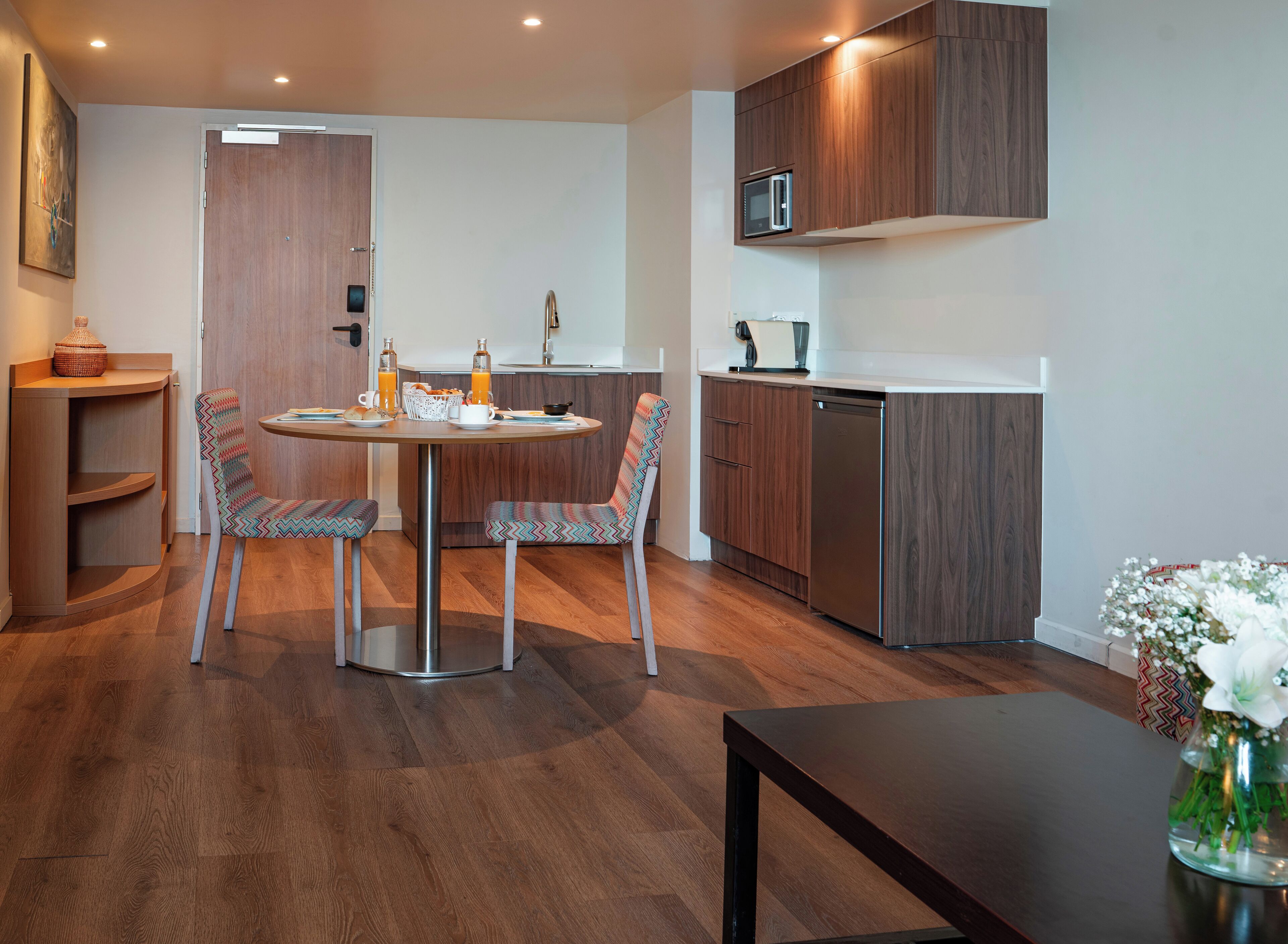 Una cocina moderna con armarios de madera, microondas integrado y lavavajillas.