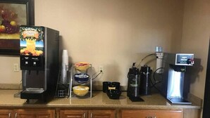 A kitchenette with a coffee machine, a fruit dispenser, and a coffee maker. - Days Inn by Wyndham Abilene (Abilene)