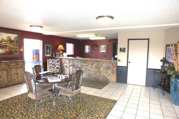 A reception area with a stone wall, a reception desk, and a patterned rug.