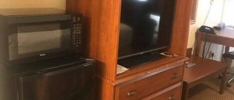 A wooden cabinet with a microwave and a television.