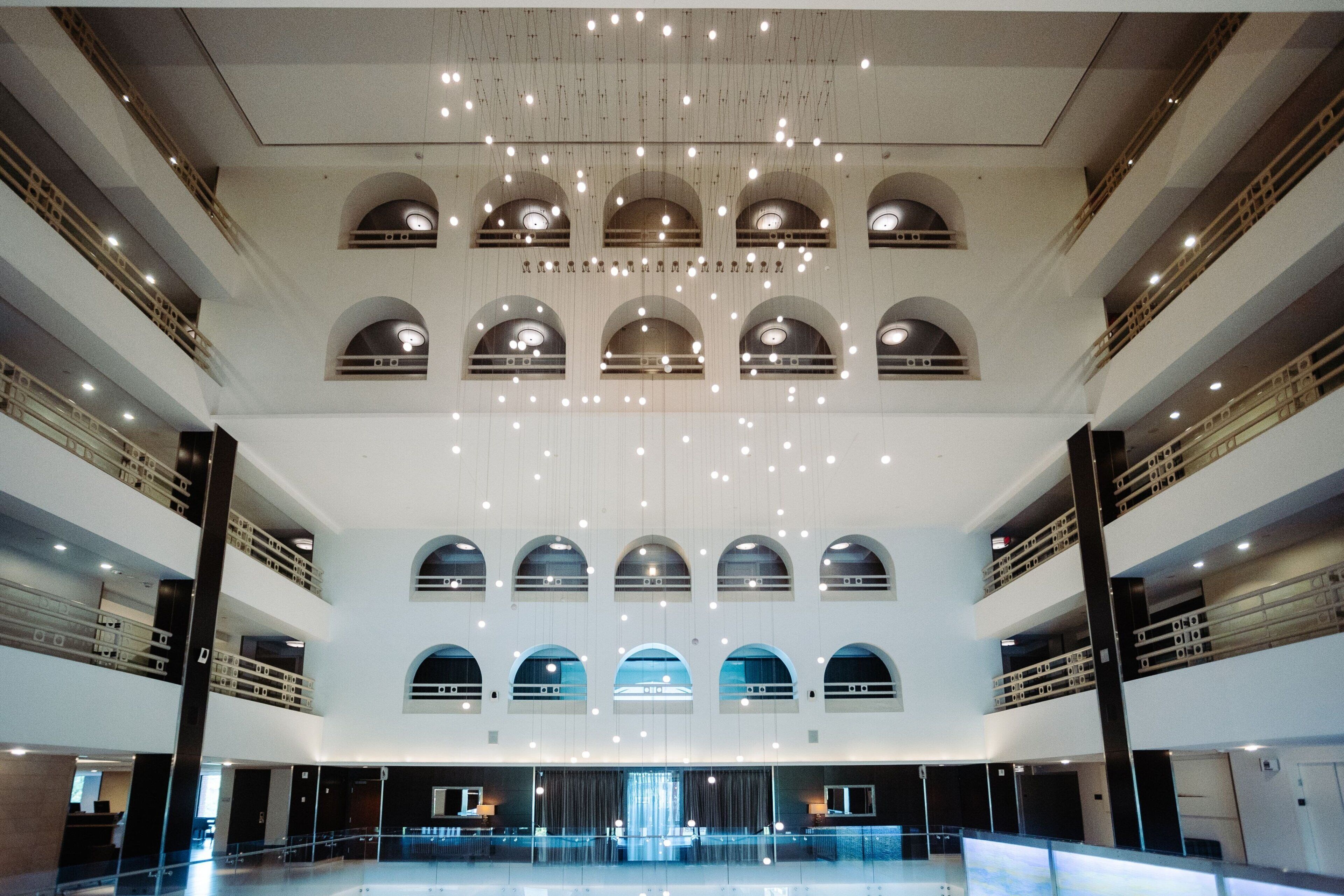 A multi-level atrium with a central open space, multiple balconies, and a series of arched windows.