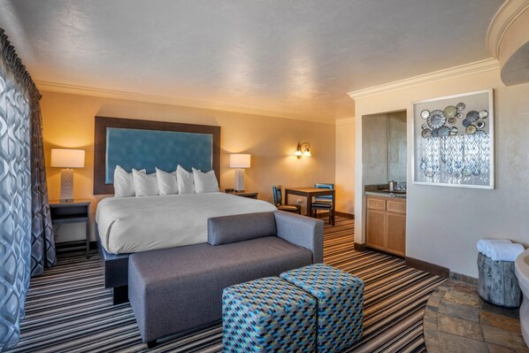 A hotel room with a large bed, a sofa, a small table, and a kitchenette. - Lincoln Sands Oceanfront Resort, an Ascend Collection Hotel (Lincoln City)