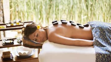 Experience a serene spa retreat with a tranquil ambiance, offering a massage table and a desk with refreshments.
