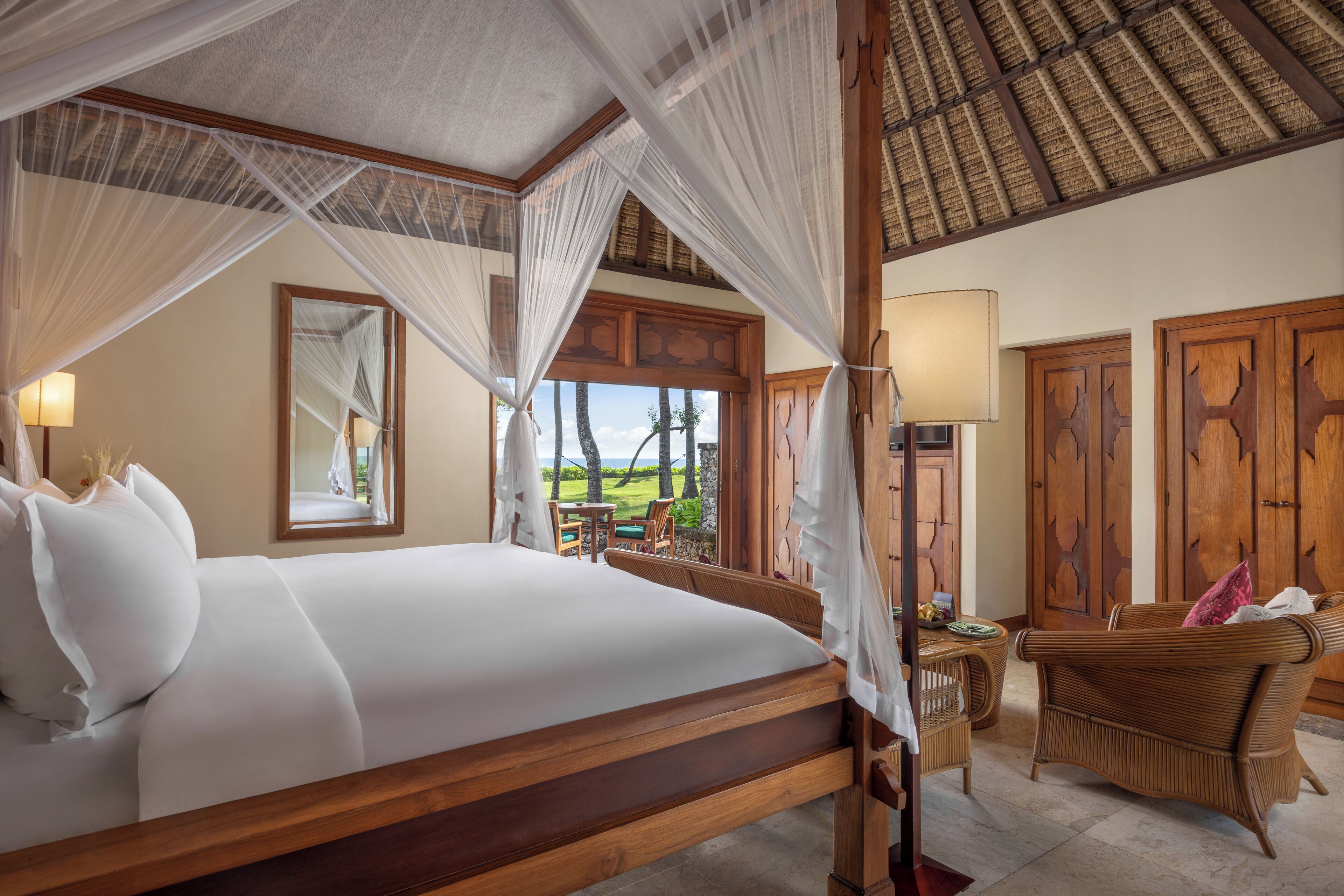 Una habitación con una cama grande, muebles de madera y vistas al exterior.