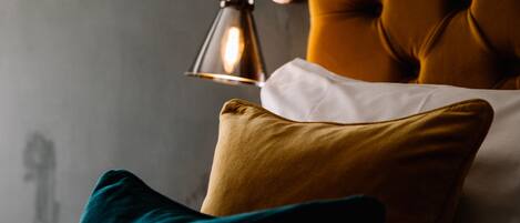 A bed with a tufted headboard, a lamp, and two pillows.