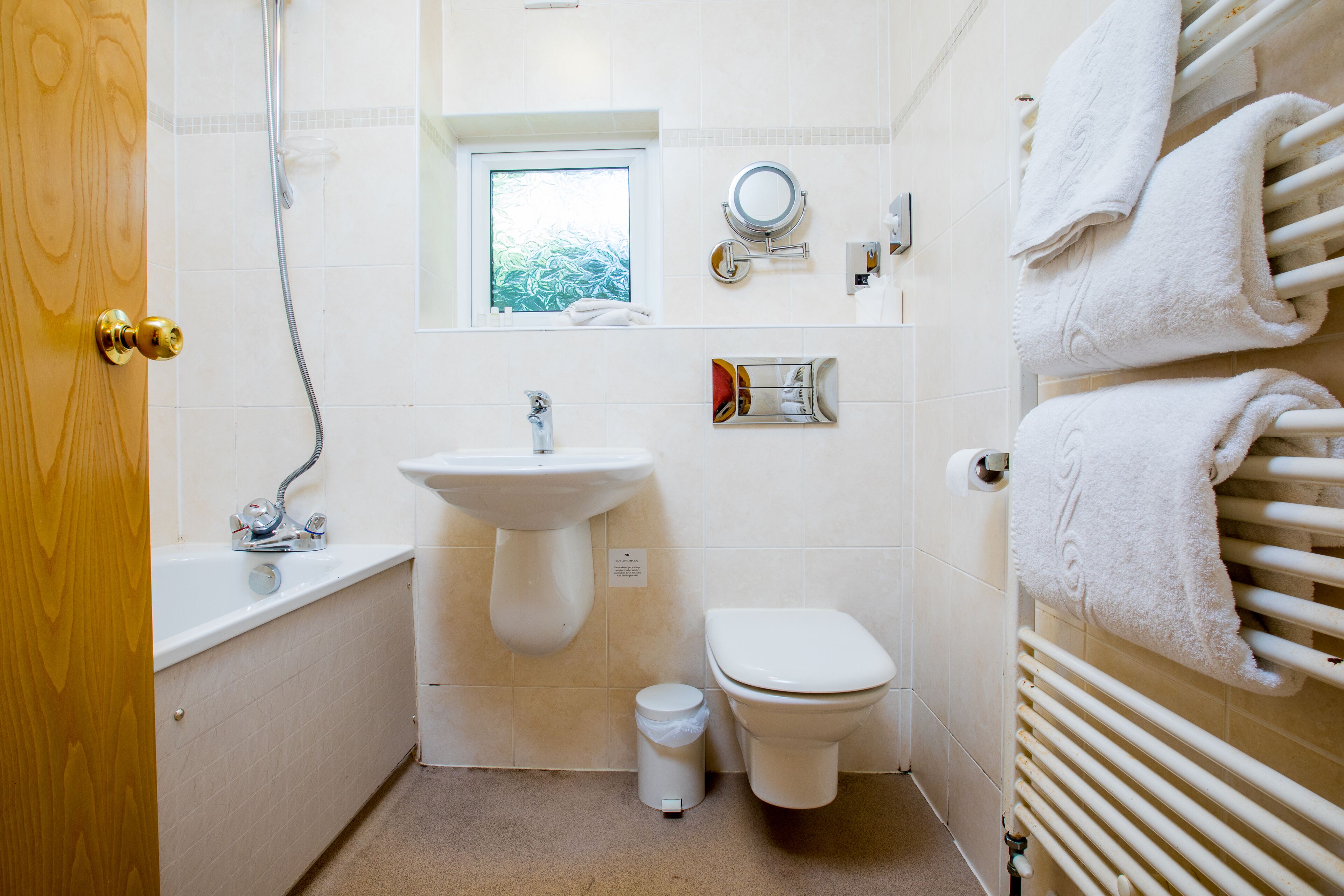 Ein Badezimmer mit Waschbecken, Toilette und Fenster.