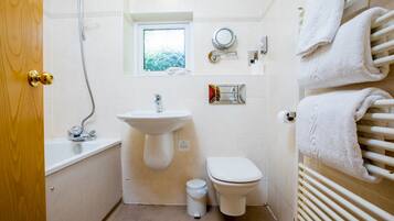 Ein Badezimmer mit Waschbecken, Toilette und Fenster.