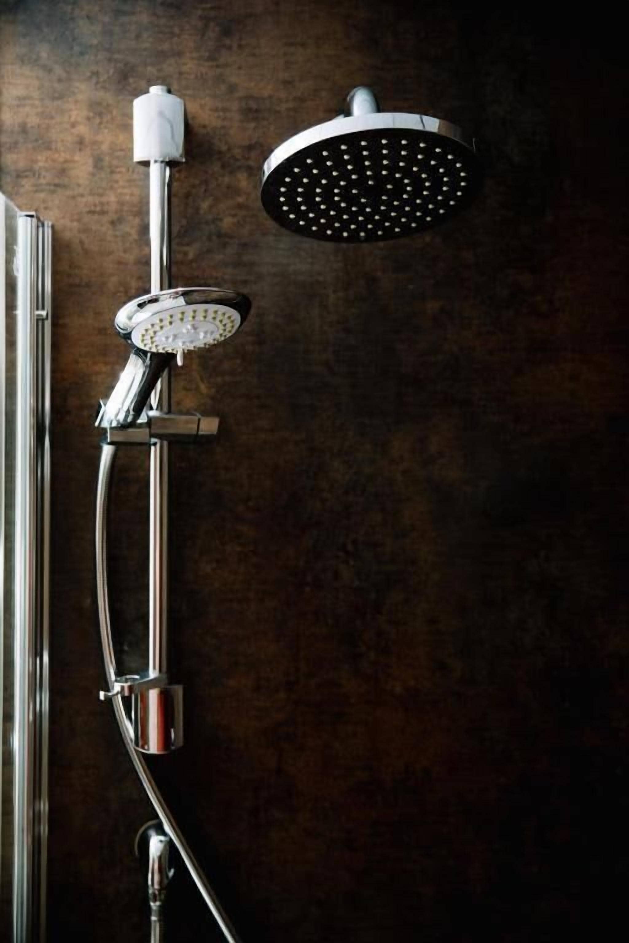 A showerhead with a circular design and a handheld shower attachment.