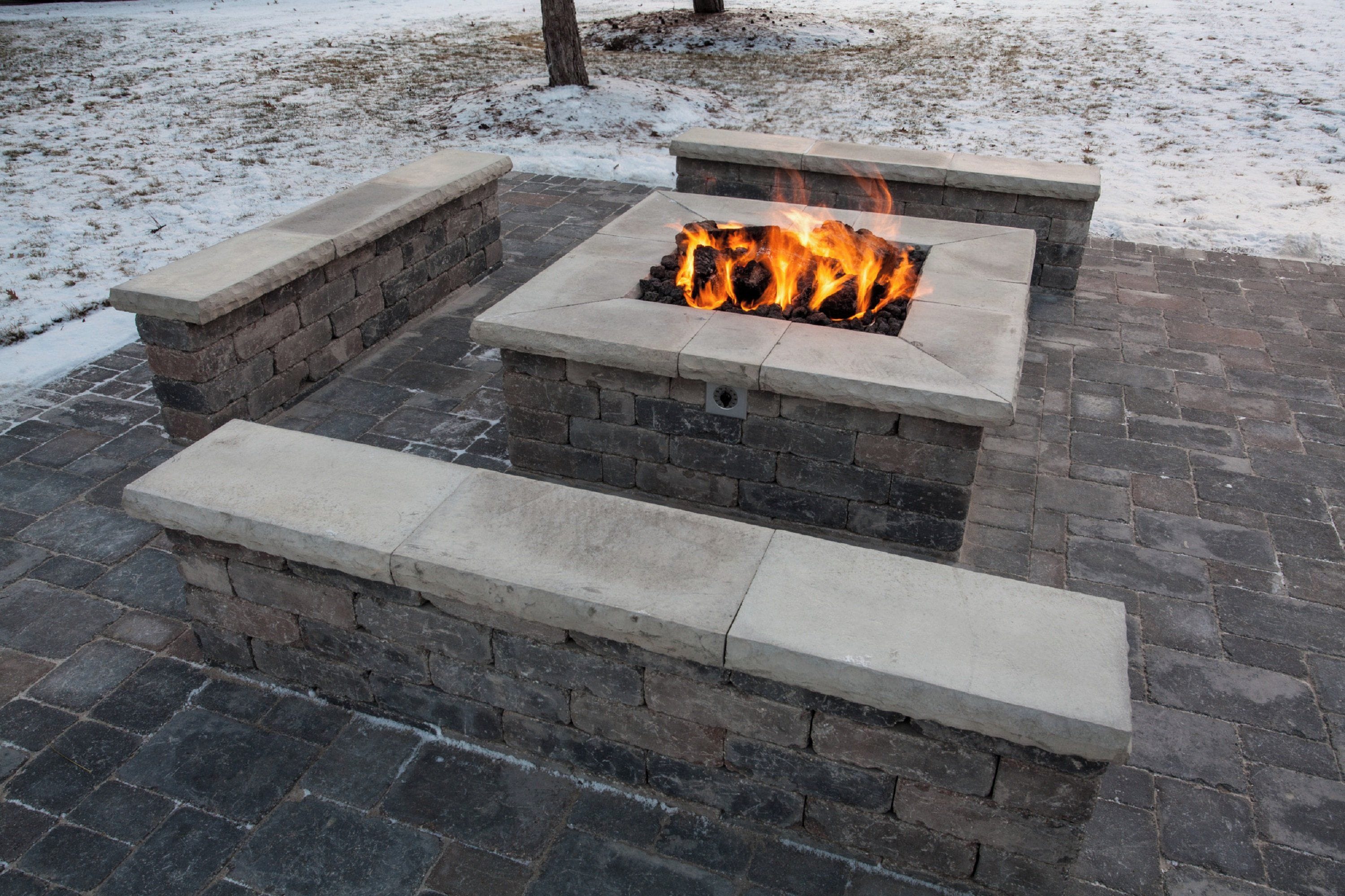 A fire pit with a stone surround and steps leading up to it.