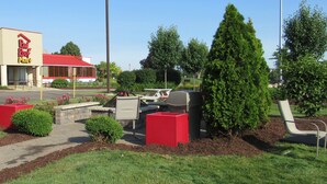 A Red Roof Plus store with a red roof and signage, surrounded by landscaped areas with bushes and a lawn. - Red Roof Inn PLUS+ Ann Arbor - U of Michigan North (Ann Arbor)