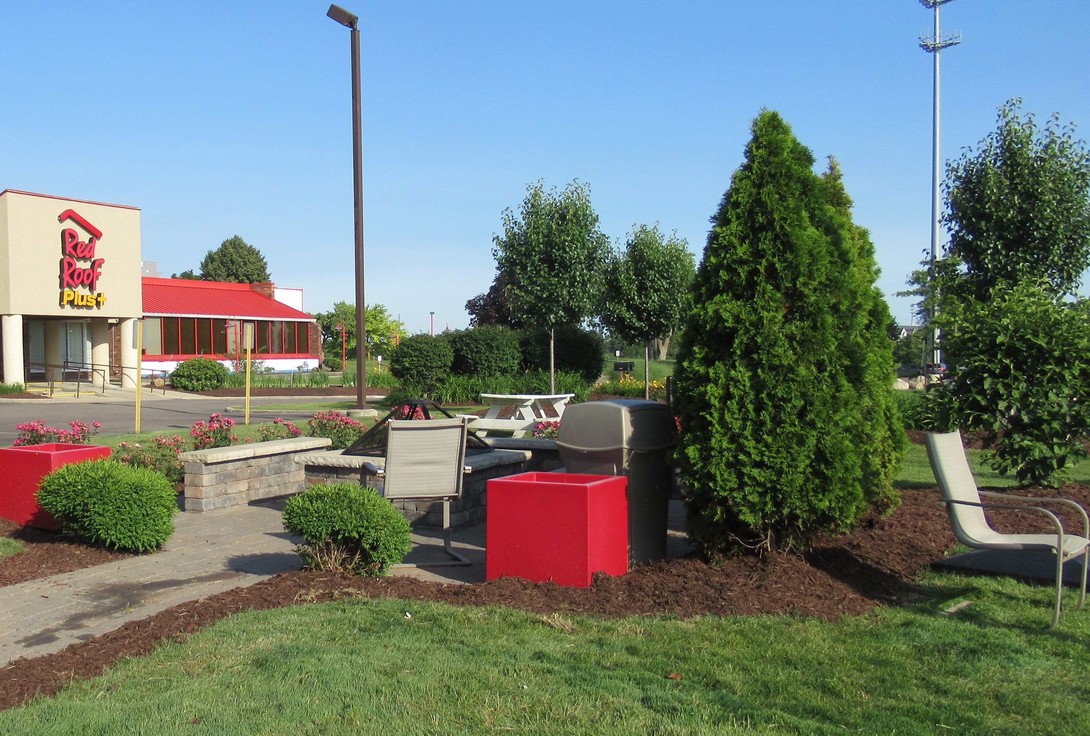 A Red Roof Plus+ restaurant with outdoor seating and landscaping.