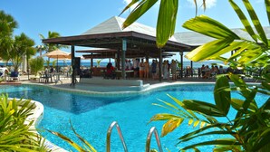 A pool area with a covered seating area, lounge chairs, and palm trees. - Barbados Beach Club Resort - All Inclusive (Maxwell)