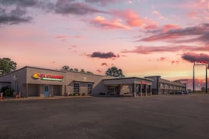 Un immeuble commercial avec une enseigne Red Roof Inn, le restaurant mexicain El Charro et un parking.