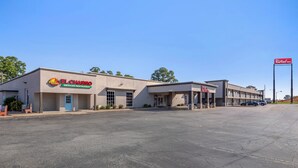 Un edificio comercial con el letrero de Red Roof Inn, el restaurante mexicano El Charro y un estacionamiento.