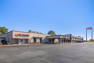 Un edificio comercial con el letrero de Red Roof Inn, el restaurante mexicano El Charro y un estacionamiento.