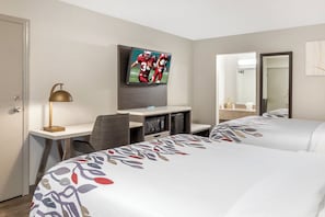 A hotel room with two beds, a desk with a computer, a TV mounted on the wall, and a mirror. - Red Roof Inn Dunn (Dunn)
