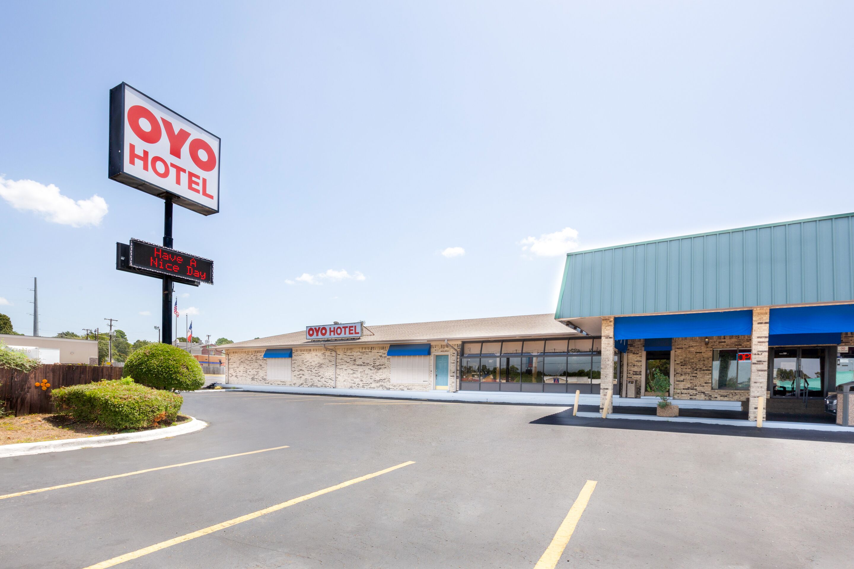 A hotel with a large sign reading "OYO HOTEL" and a digital display saying "Have a Nice Day."