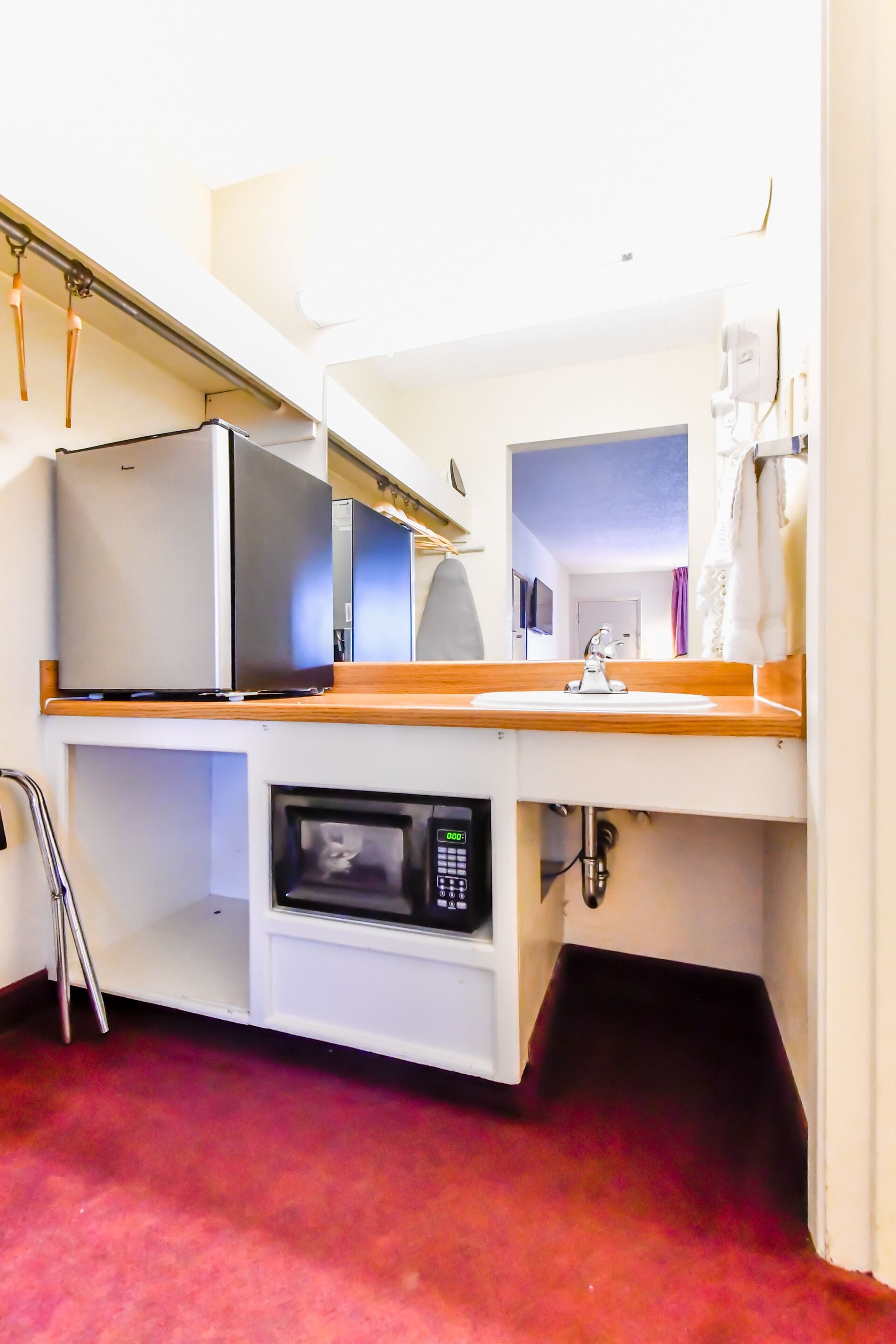 A compact kitchenette with a microwave, a small refrigerator, and a sink.