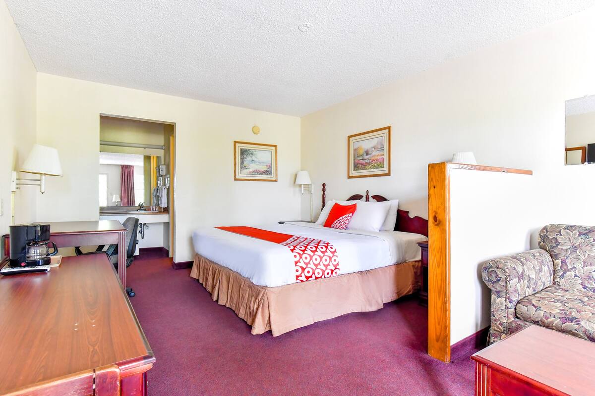 Ein Hotelzimmer mit einem Bett, einem Schreibtisch, einem Sessel und einer Couch.