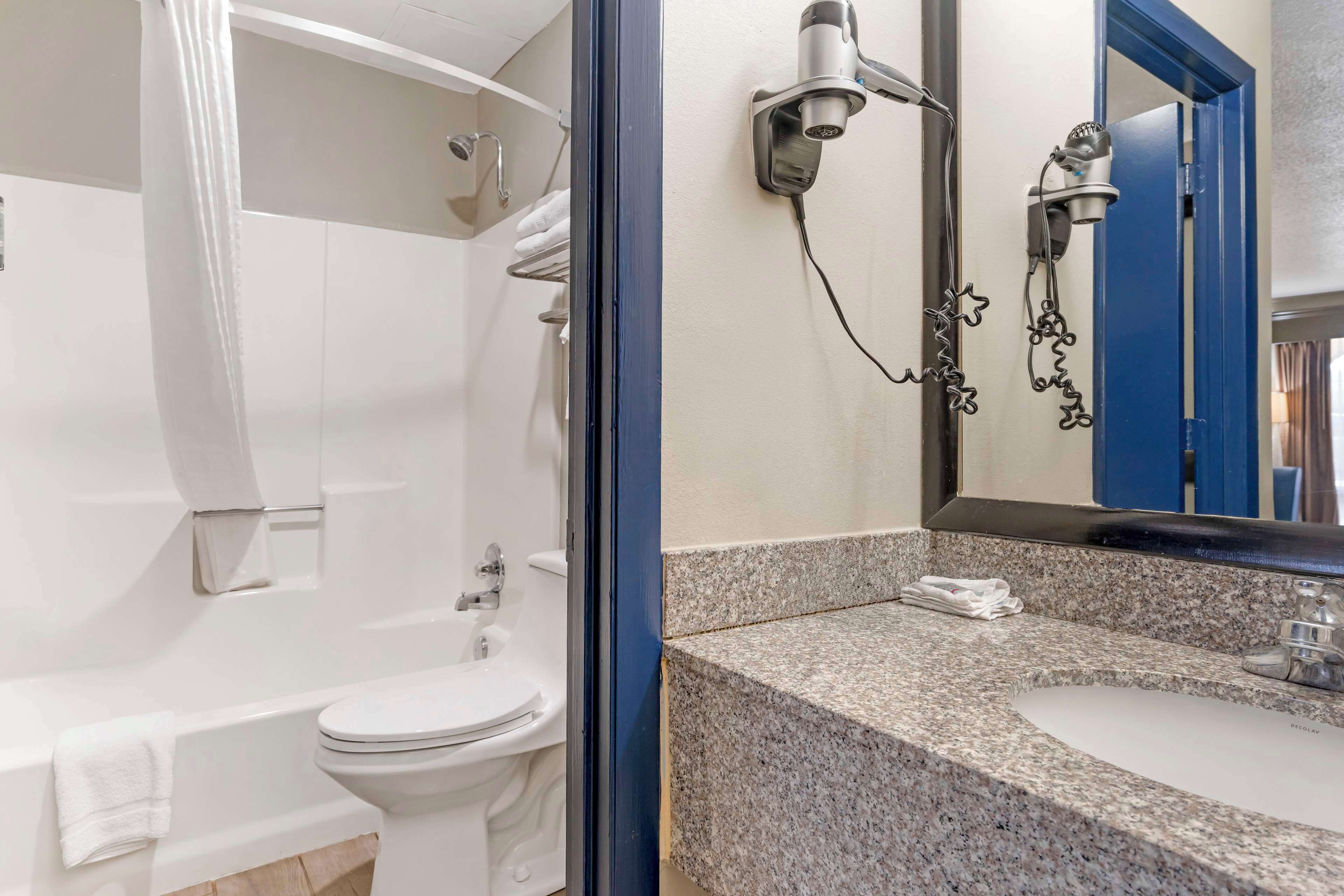 A bathroom with a white toilet, a sink, and a shower.