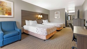 A hotel room with two beds, a blue armchair, a desk, and a large abstract painting on the wall. - Best Western Royal Inn (Chattanooga)