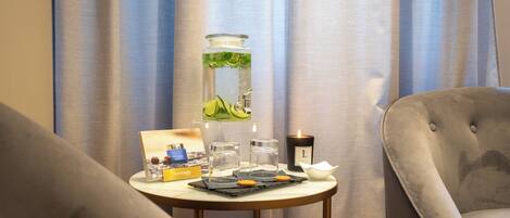 Una habitación con una mesa redonda que incluye una vela, un tarro de cristal con una planta y una bandeja con galletas.