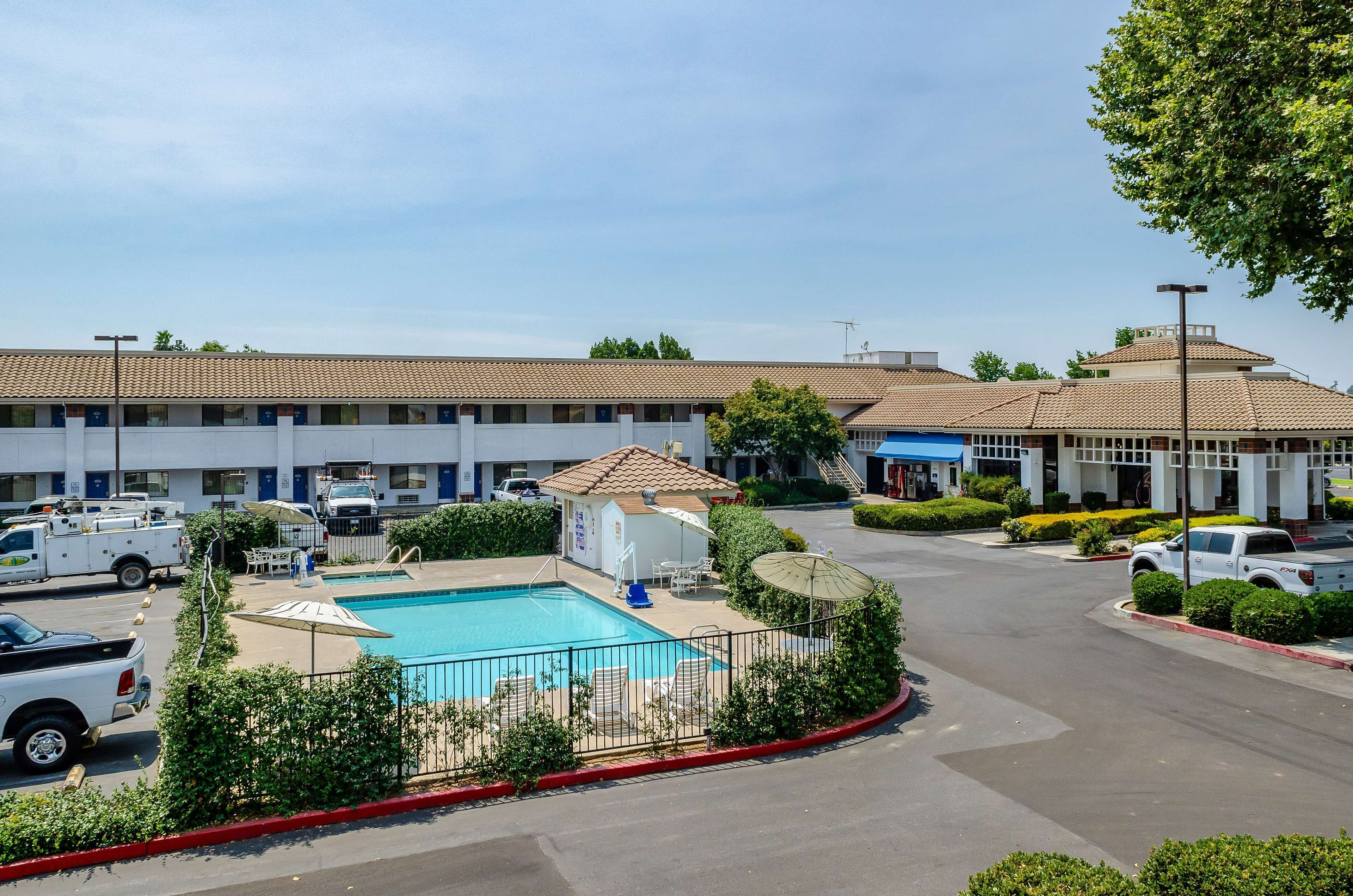 Ein Hotel mit Schwimmbad, Außenbereich und Parkplatz.