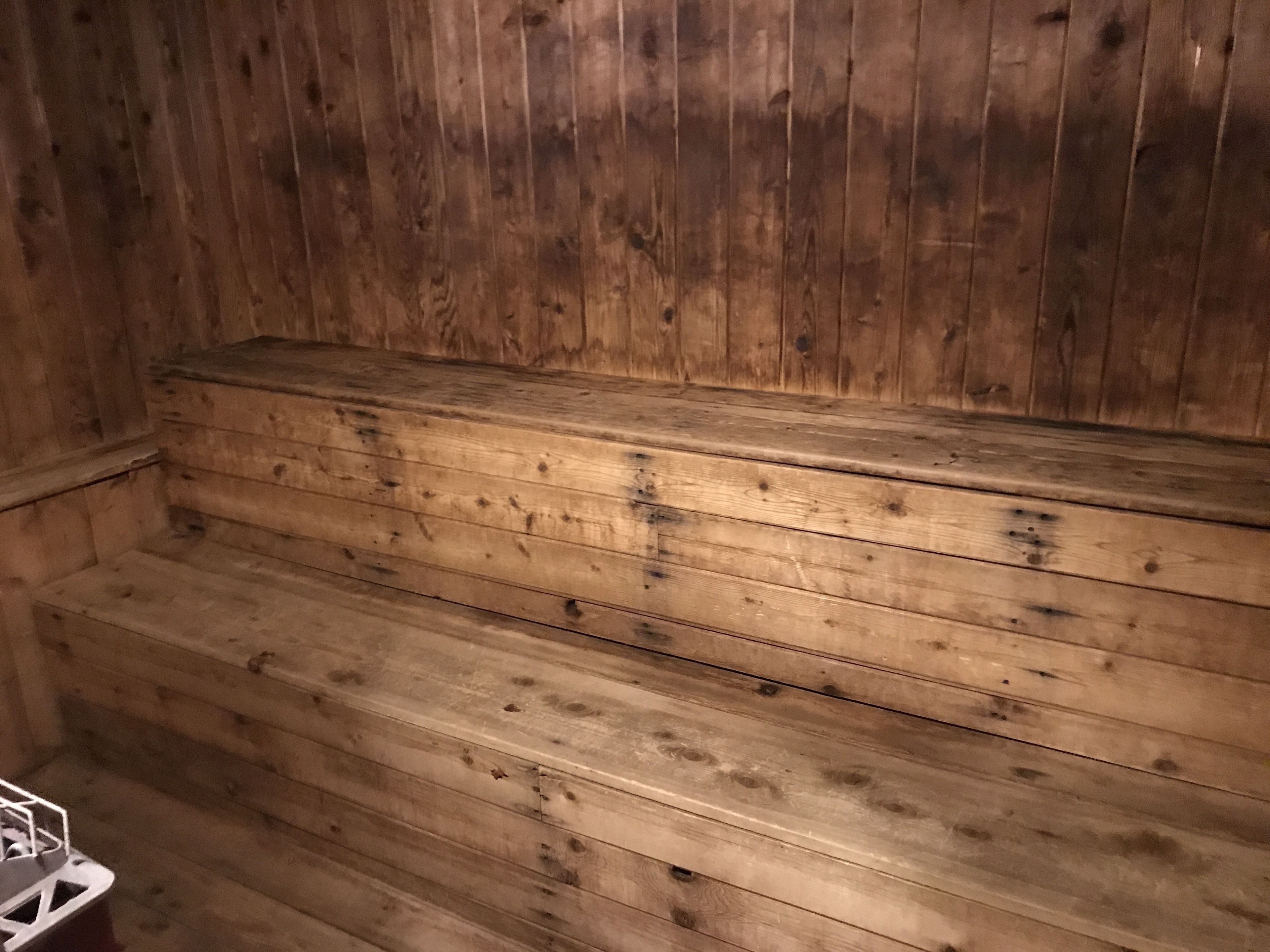 Um banco de madeira com design em ripas, possivelmente parte de uma sauna ou sala de vapor.