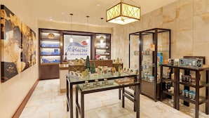 Un spa y salón de belleza con zona de recepción, vitrinas de vidrio y un mostrador de recepción.