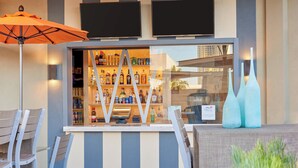 A bar area with striped seating, a counter with a liquor display, and two large vases. - The Westin Las Vegas Hotel & Spa (Las Vegas)