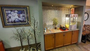 Um espaço compacto com cozinha compacta, um relógio, um sofá e uma árvore decorativa.