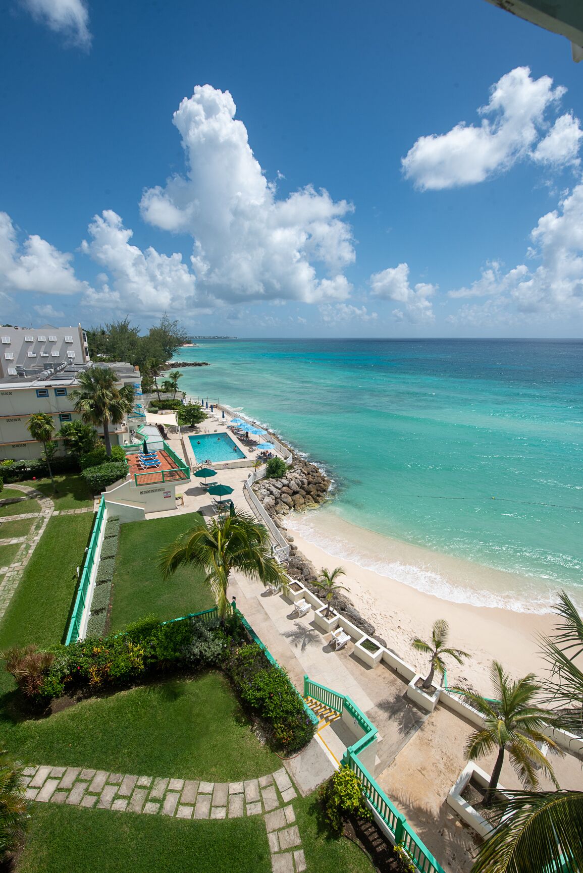 A resort with a swimming pool, beach, and ocean view.