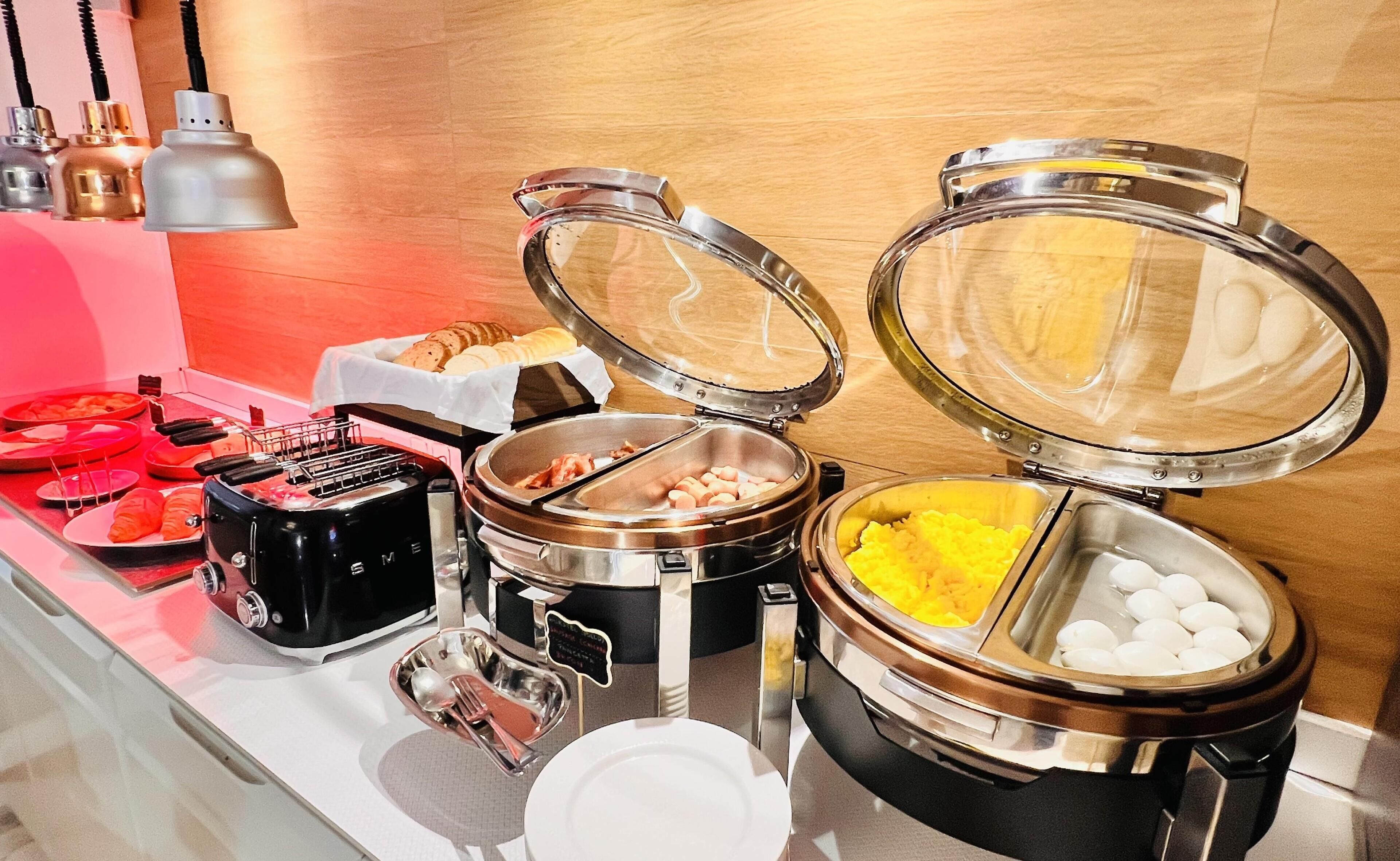 Een buffetopstelling met verschillende soorten eten en bestek.