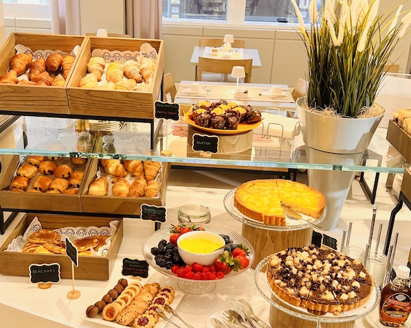 A bakery display with pastries, muffins, and a variety of desserts.