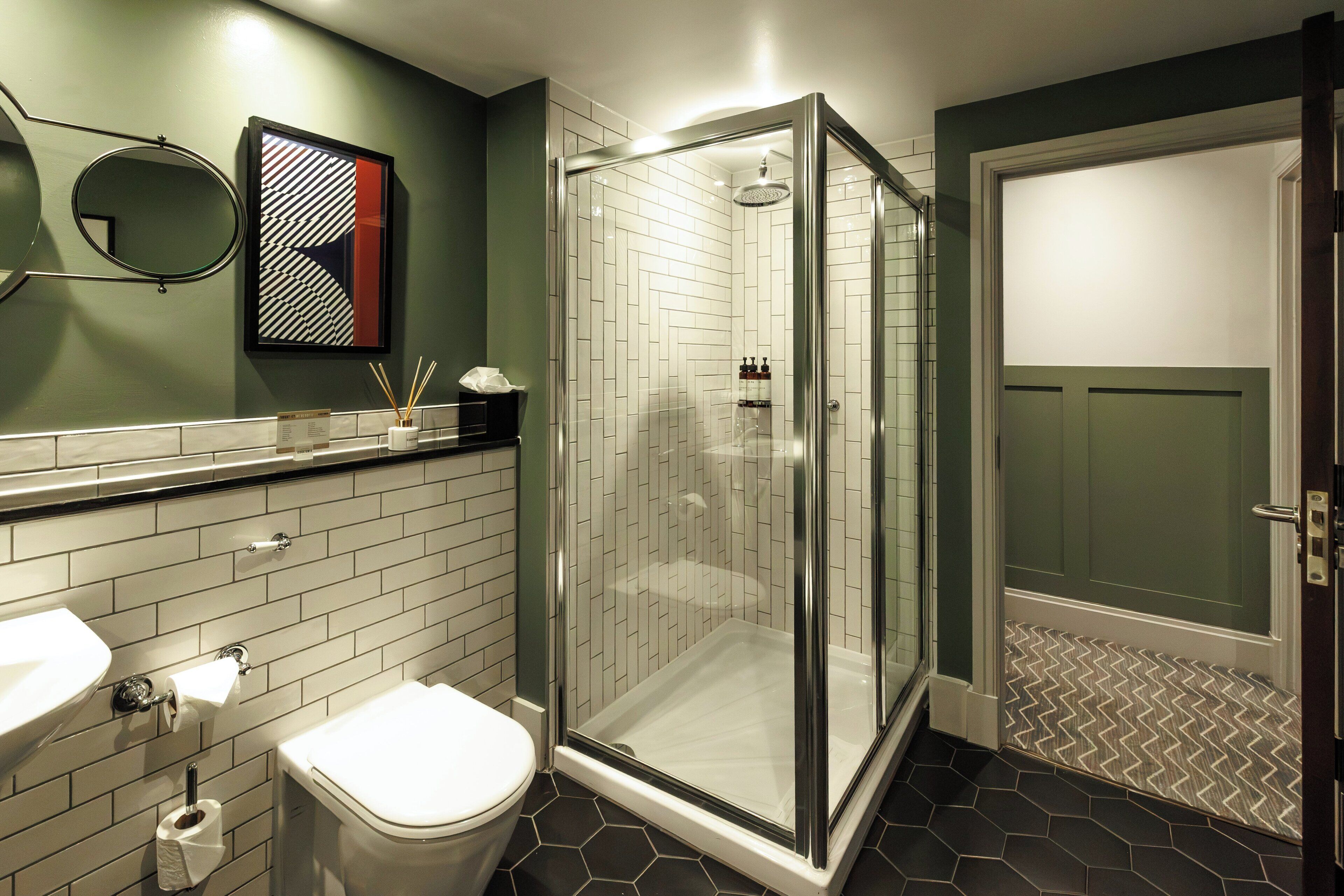 Un baño con ducha de vidrio, inodoro, lavabo y espejo.
