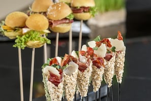 A variety of food items, including skewers with vegetables and meat, and sandwiches.