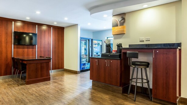 Une cuisine moderne avec des meubles en bois, un coin bar et un réfrigérateur.
