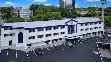 A multi-story building with a flat roof, a parking lot with marked spaces, and a clear view of the surrounding urban landscape.