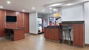 Une cuisine moderne avec des meubles en bois, un coin bar et un réfrigérateur rempli de boissons.