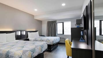 Habitación de hotel con dos camas, un escritorio, una silla, un televisor y una ventana con cortinas.