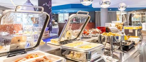 A buffet with various food options, including hot dogs, salads, and desserts.