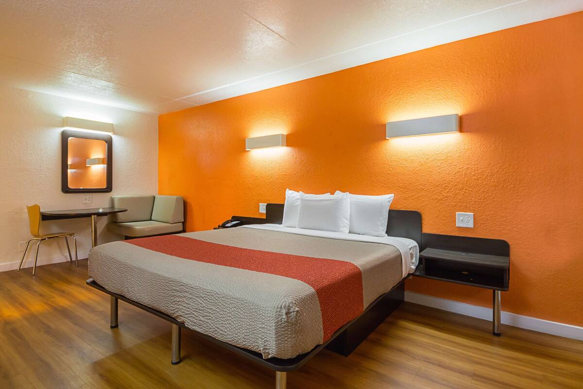 Une chambre d’hôtel avec un lit, un bureau et une chaise.